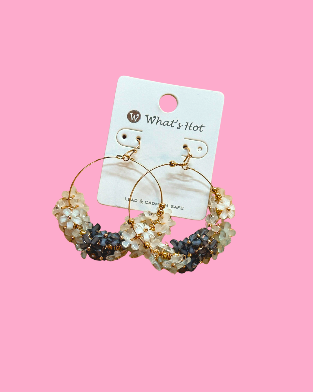Pair of hoop earrings with beads on a 'What's Hot' branded card against a pink background