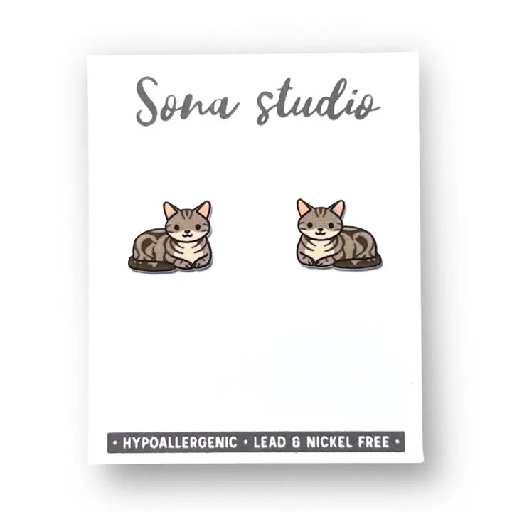 Cat-shaped earrings on a card with 'Sona Studio' branding and safety information.