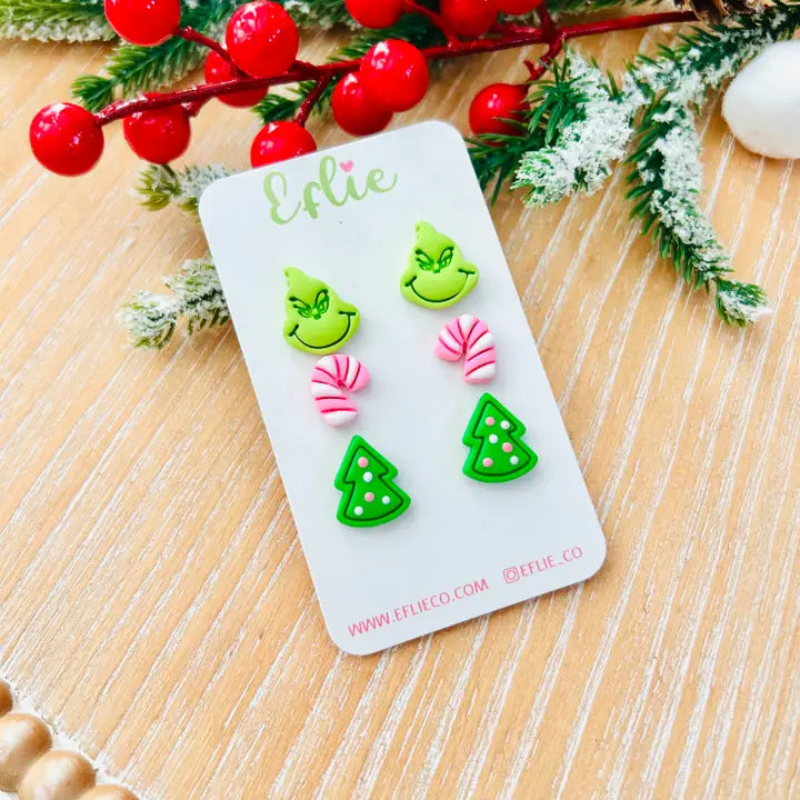 Set of festive earrings on a branded card with Christmas decorations in the background
