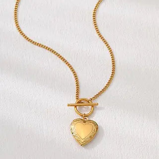 Gold heart-shaped pendant on a chain against a white background