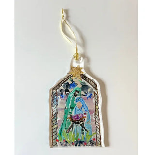 A hand-painted glass or acrylic ornament shaped like a stable, featuring a colorful illustration of Mary and baby Jesus with a gold star at the top and a hanging loop.