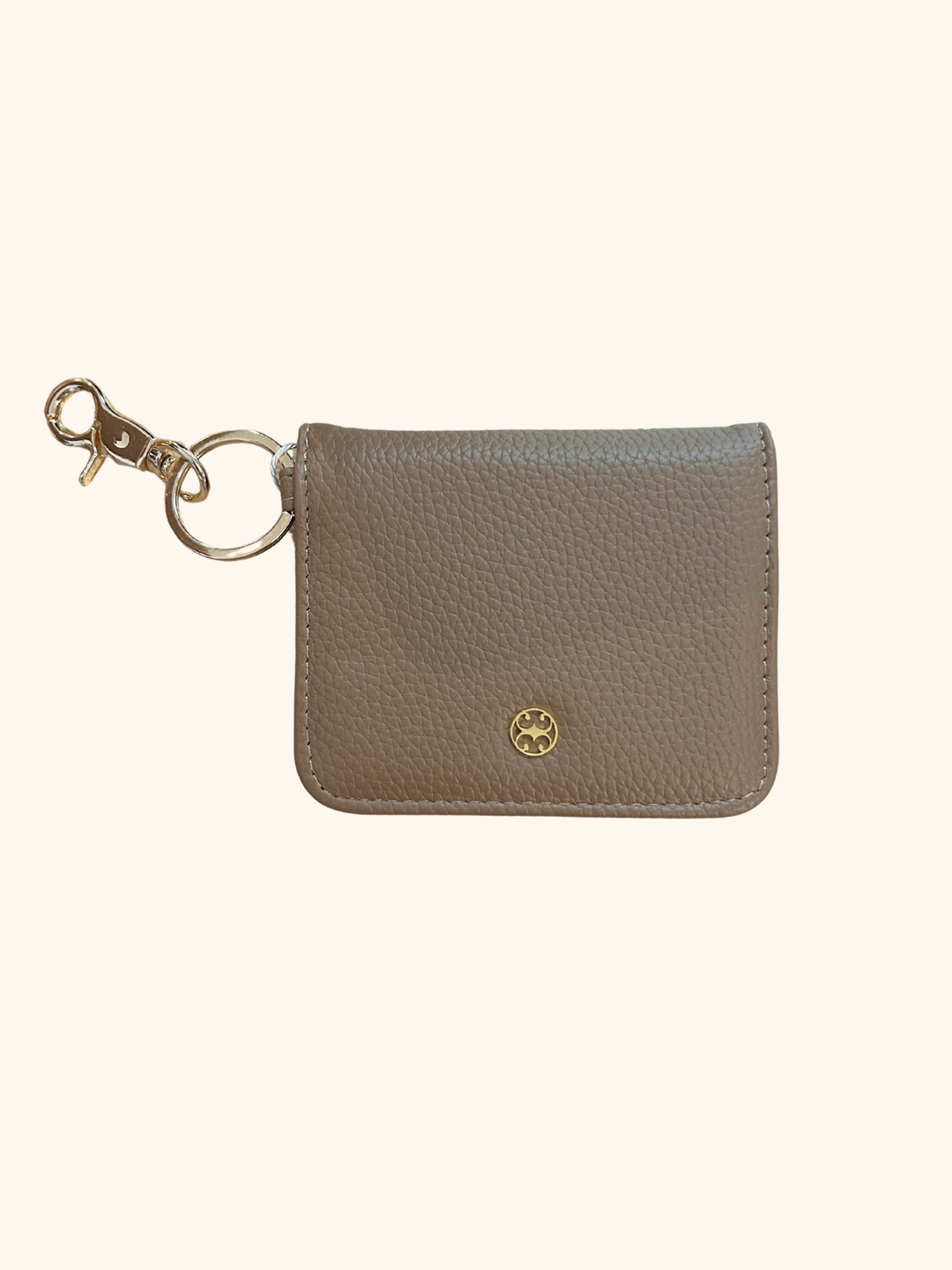 Small beige cardholder with keychain on a white background