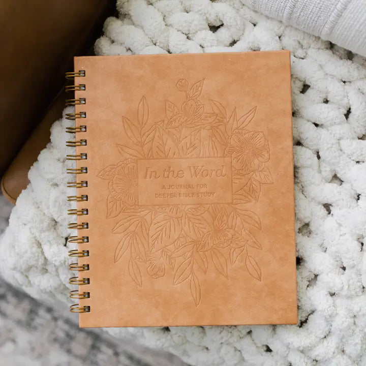 Brown notebook with embossed design and text on a textured white surface