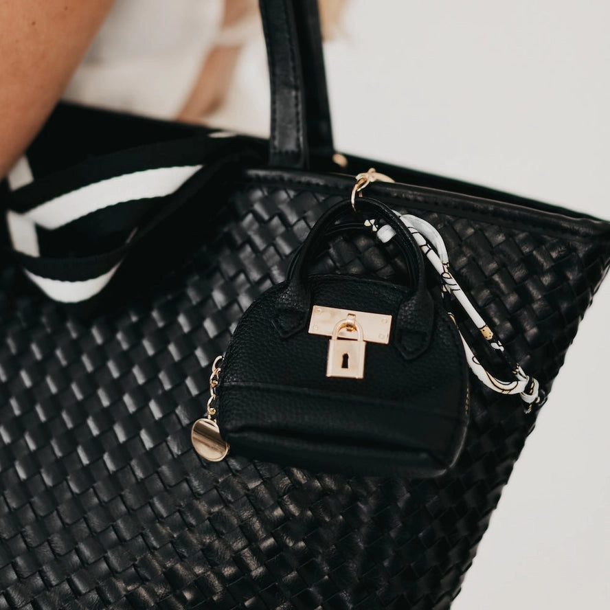 Black handbag with a smaller black bag attached, featuring a gold lock detail.