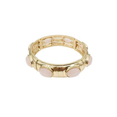 Gold ring with pink gemstone on a white background