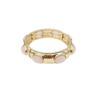 Gold ring with pink gemstone on a white background