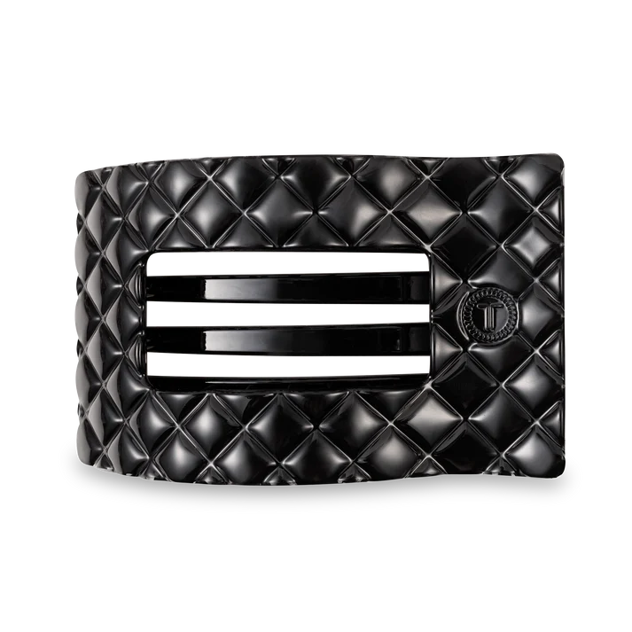 Black quilted flat hair clip on a white background