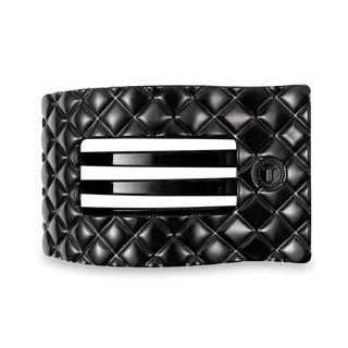 Black quilted flat hair clip on a white background