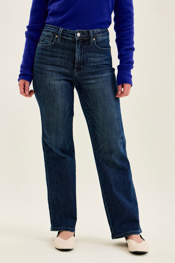 Person wearing blue jeans and a purple sweater on a white background