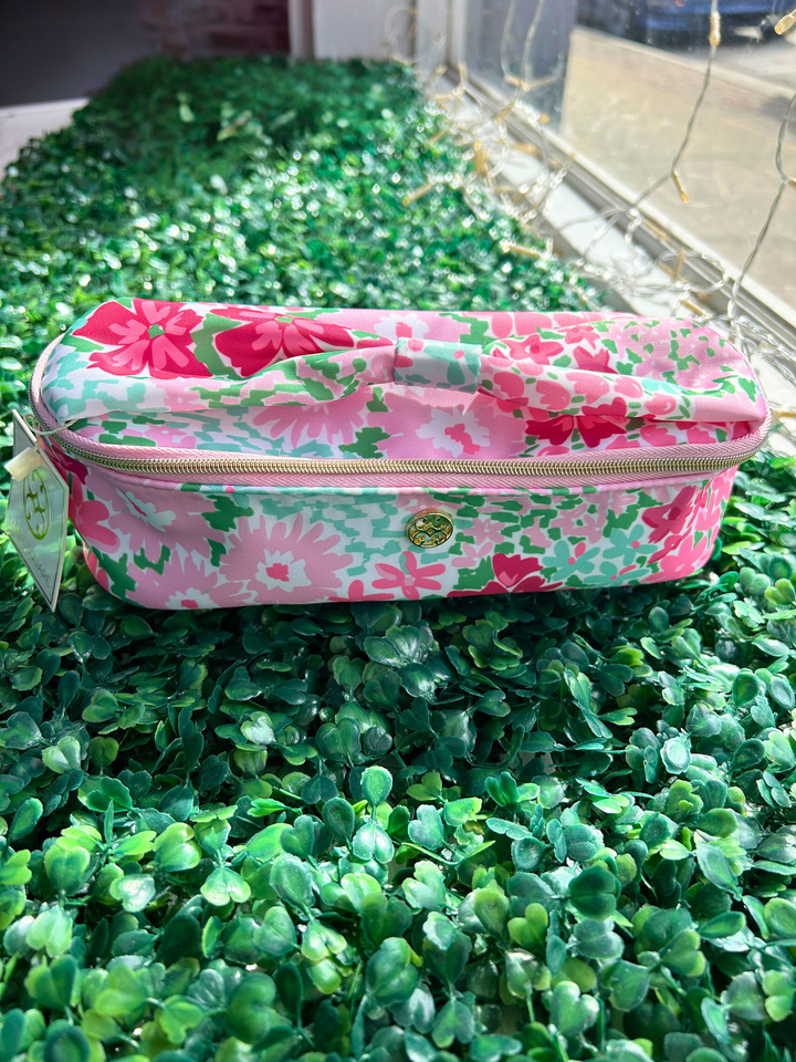 Floral-patterned pencil case on a green surface