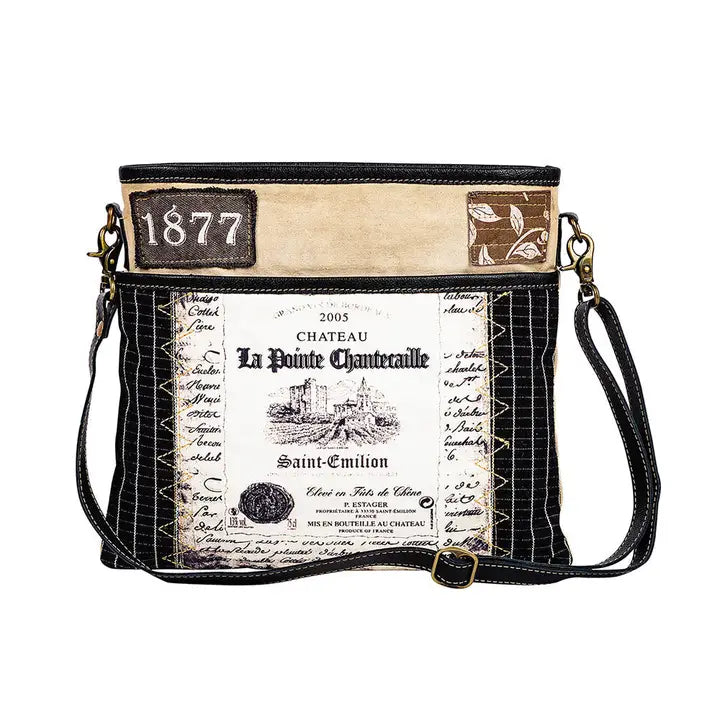 Crossbody bag with vintage wine label design on a white background
