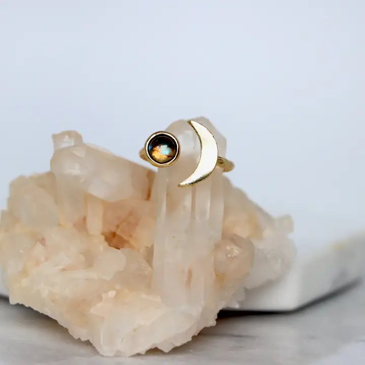 Gold ring with a black gemstone on a white crystal background