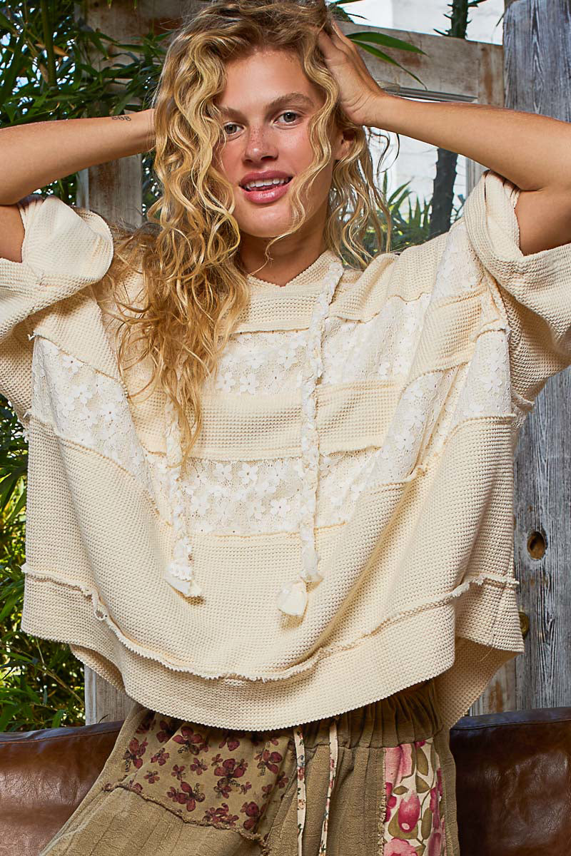 woman wearing cream colored hoodie with lace patchwork