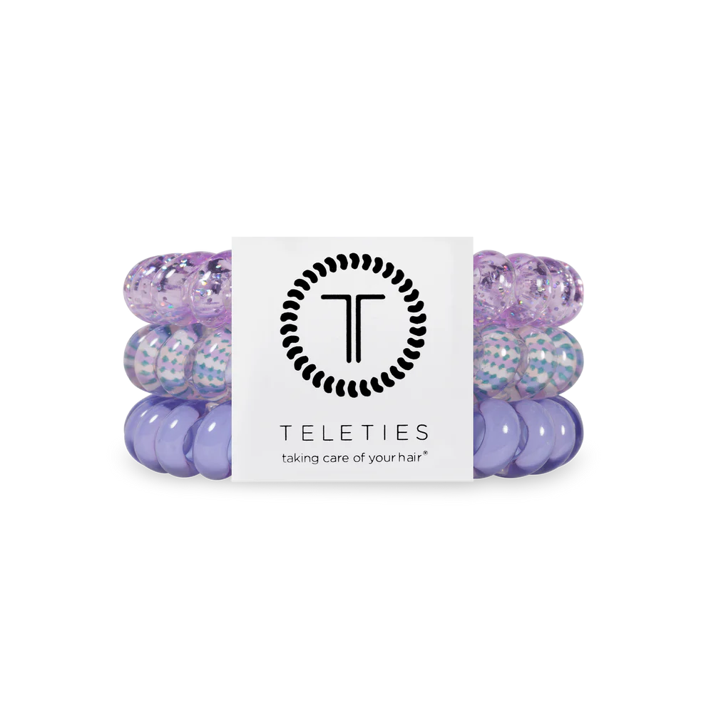 Set of purple hair ties with a Teleties branded card on a white background