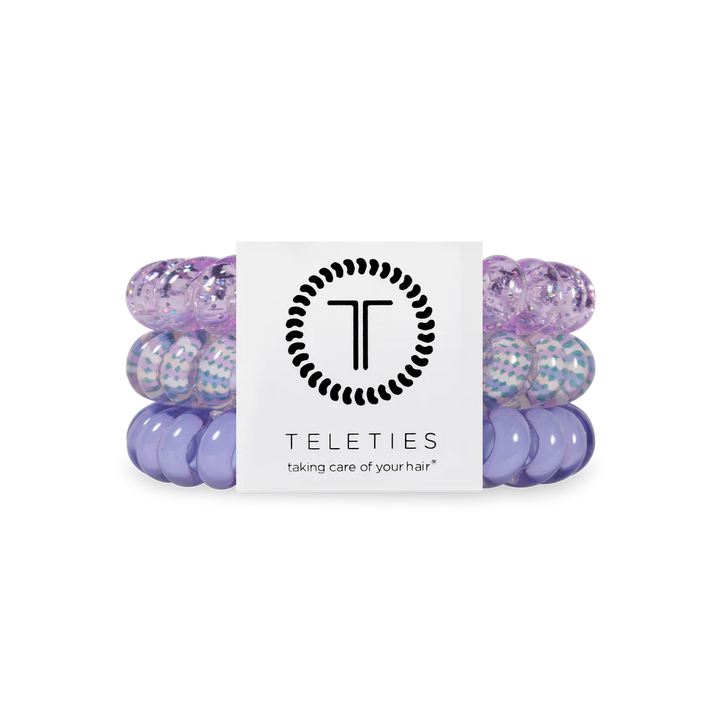 Set of purple hair ties with a Teleties branded card on a white background