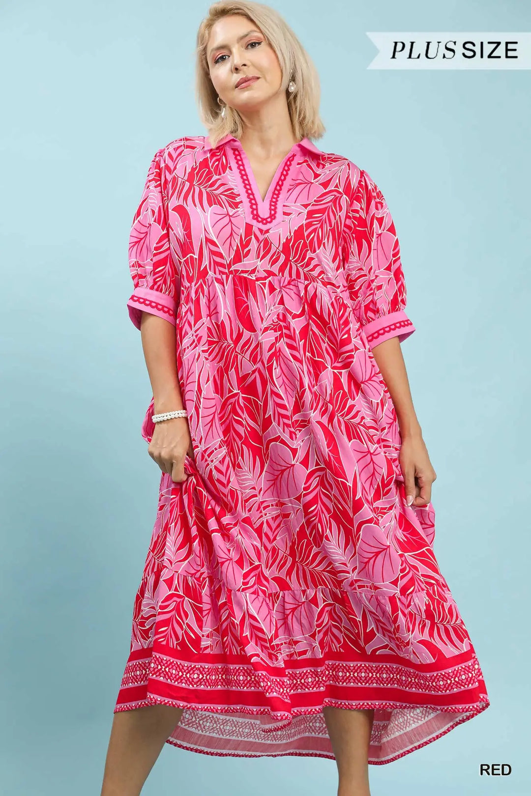 Woman wearing a pink and white patterned dress on a light blue background