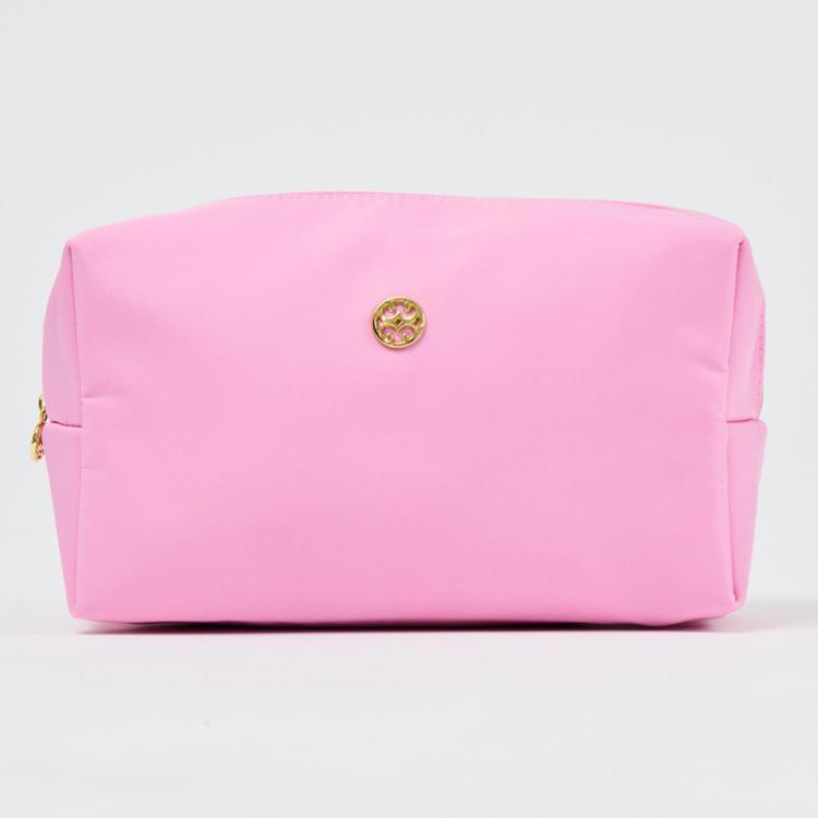 Pink cosmetic bag with a gold logo on a light gray background