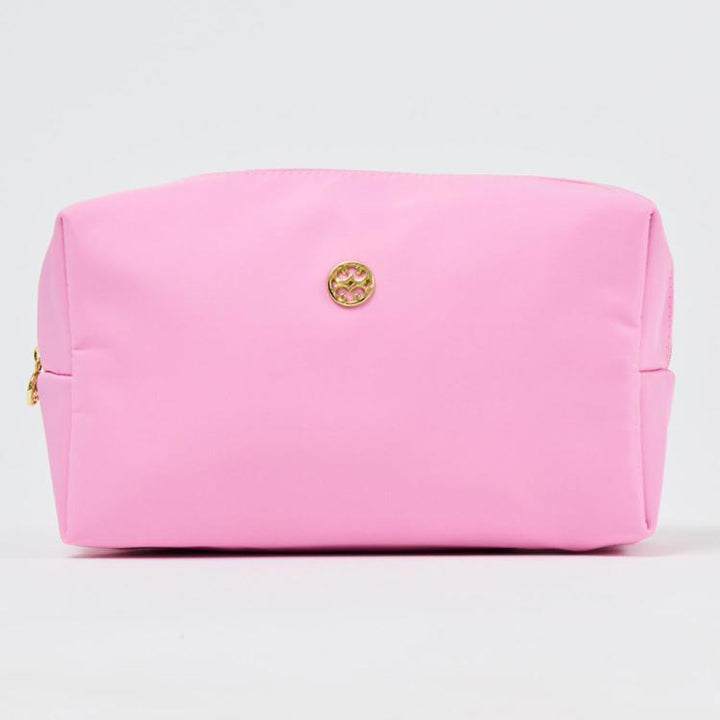Pink cosmetic bag with a gold logo on a light gray background
