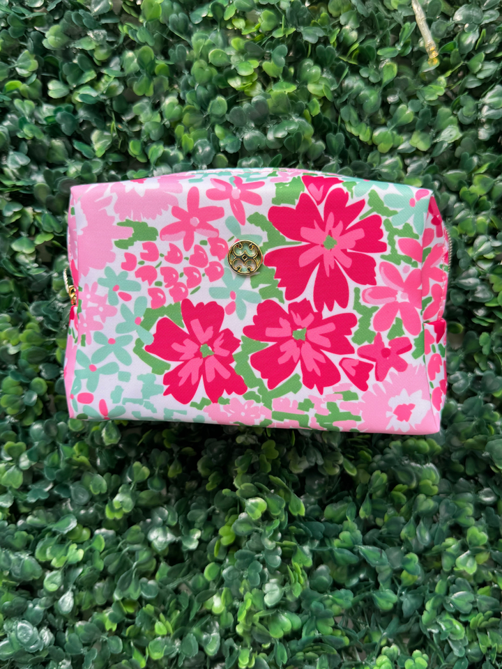 Floral-patterned clutch bag on a green textured surface