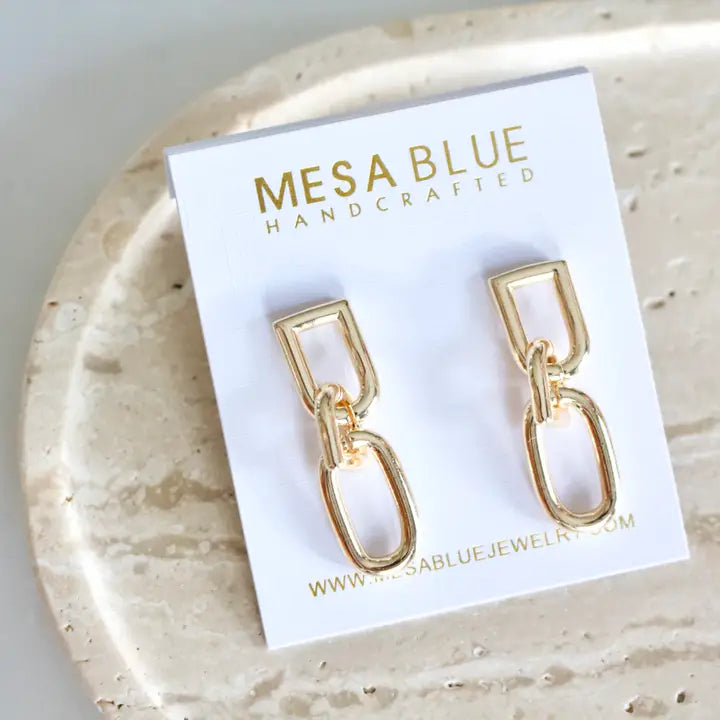 Gold chain earrings on a Mesa Blue branded card.
