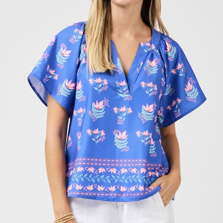 Woman wearing a blue floral patterned blouse against a white background