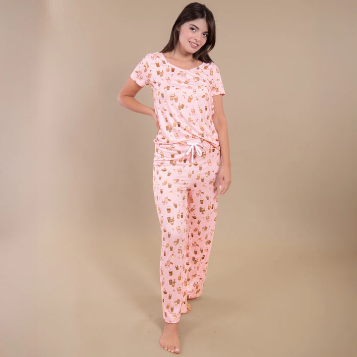 Woman wearing a pink floral pajama set against a beige background