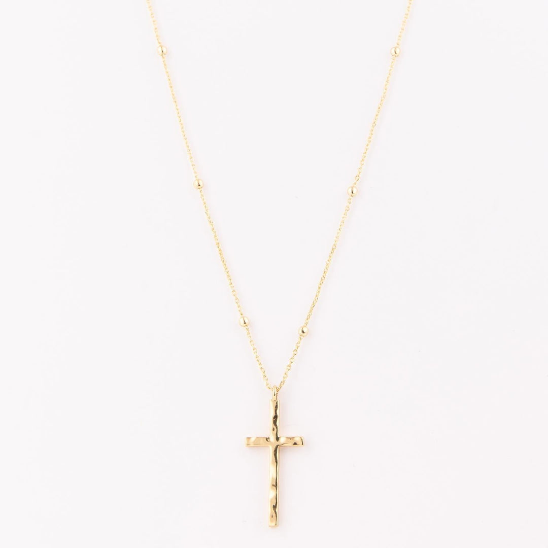 Gold cross necklace on a white background