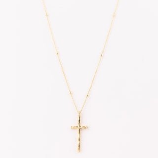 Gold cross necklace on a white background