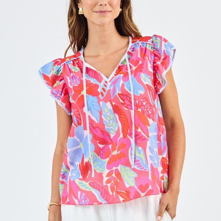 Woman wearing a colorful floral top on a white background
