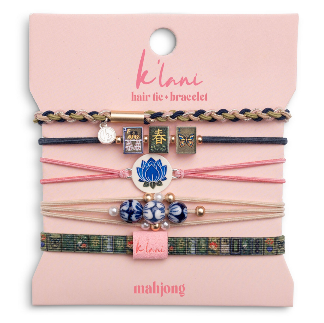 Set of hair ties and bracelets on a pink card with &
