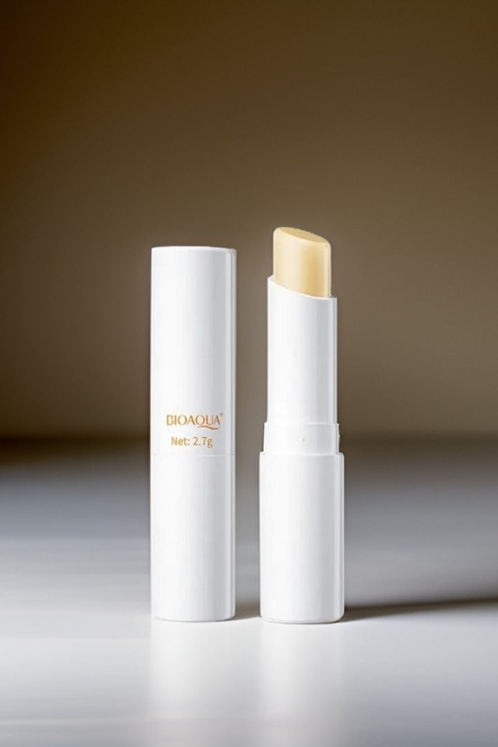 Lip balm with open white container on a reflective surface