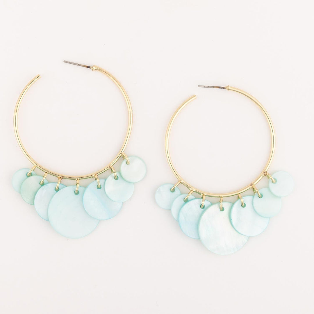 Gold hoop earrings with light blue circular charms on a white background