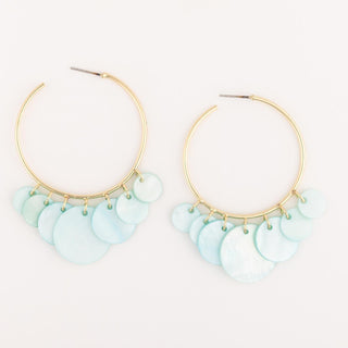 Gold hoop earrings with light blue circular charms on a white background
