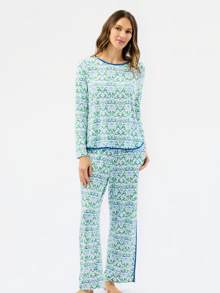 woman wearing long sleeve and pants pajama set with green and blue festive pattern