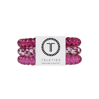 Three pink translucent beaded hair extension bands wrapped together with a white Teleties brand label, shown on a plain white background.