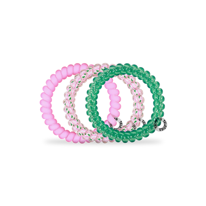 Set of pink and green beaded bracelets on a white background