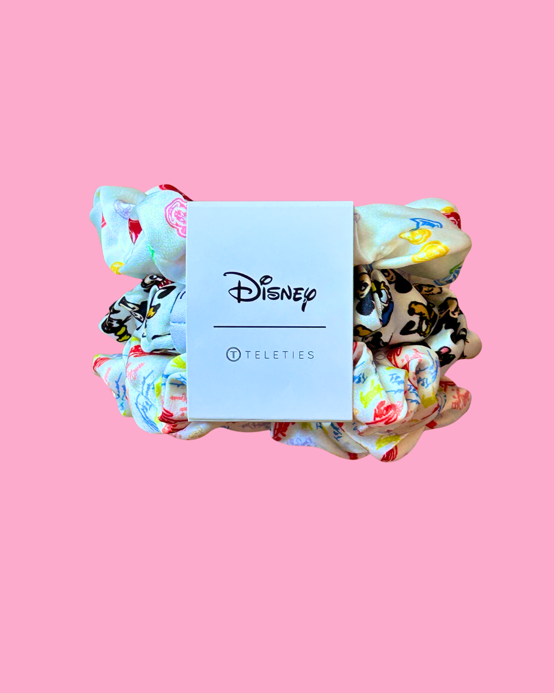 Set of colorful scrunchies with a Disney Teleties label on a pink background