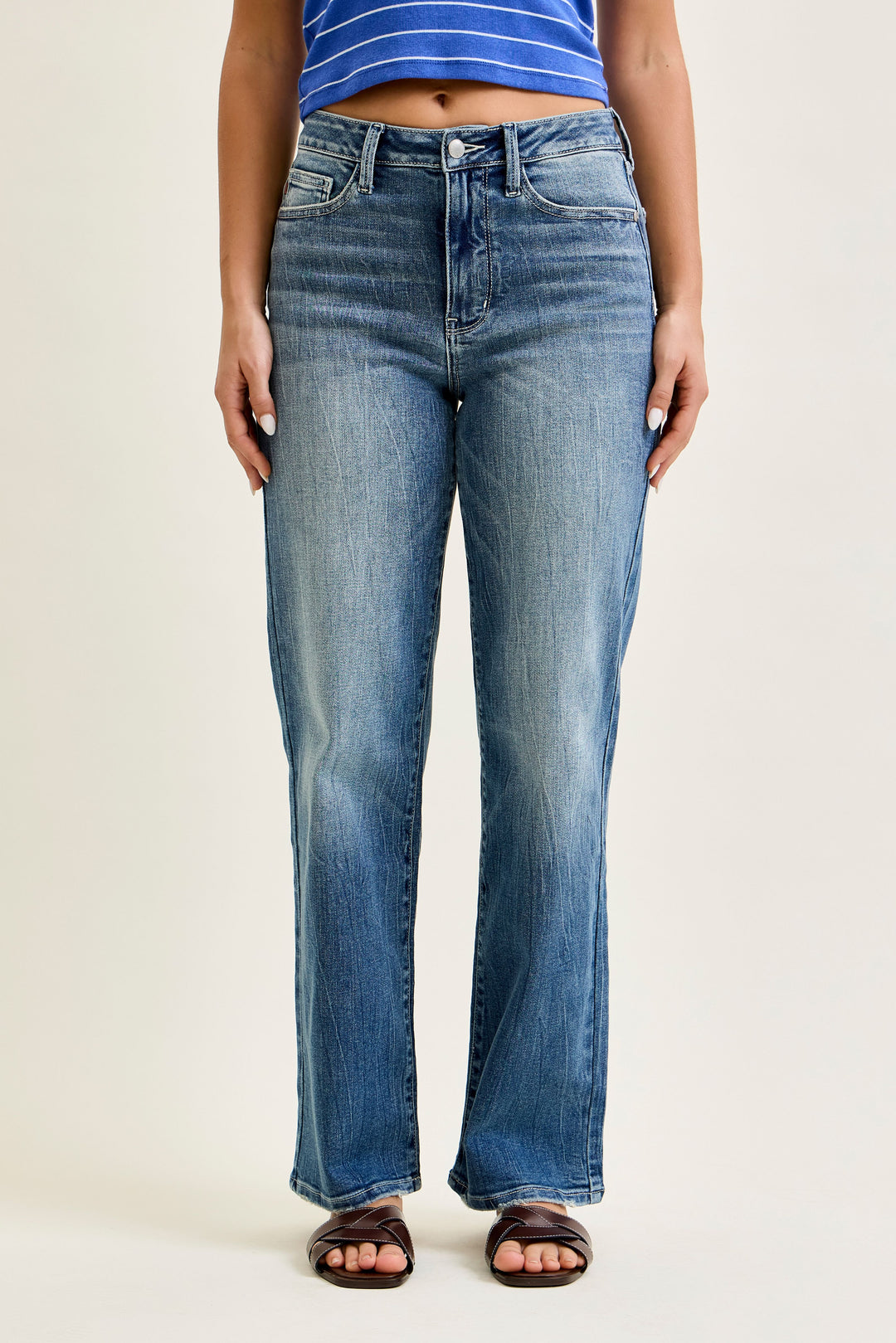 Person wearing blue jeans on a plain background