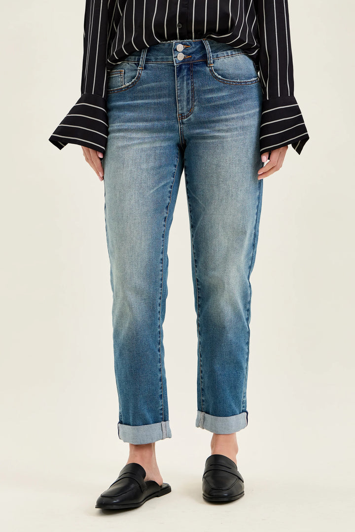 Person wearing blue jeans and a black and white striped shirt on a beige background
