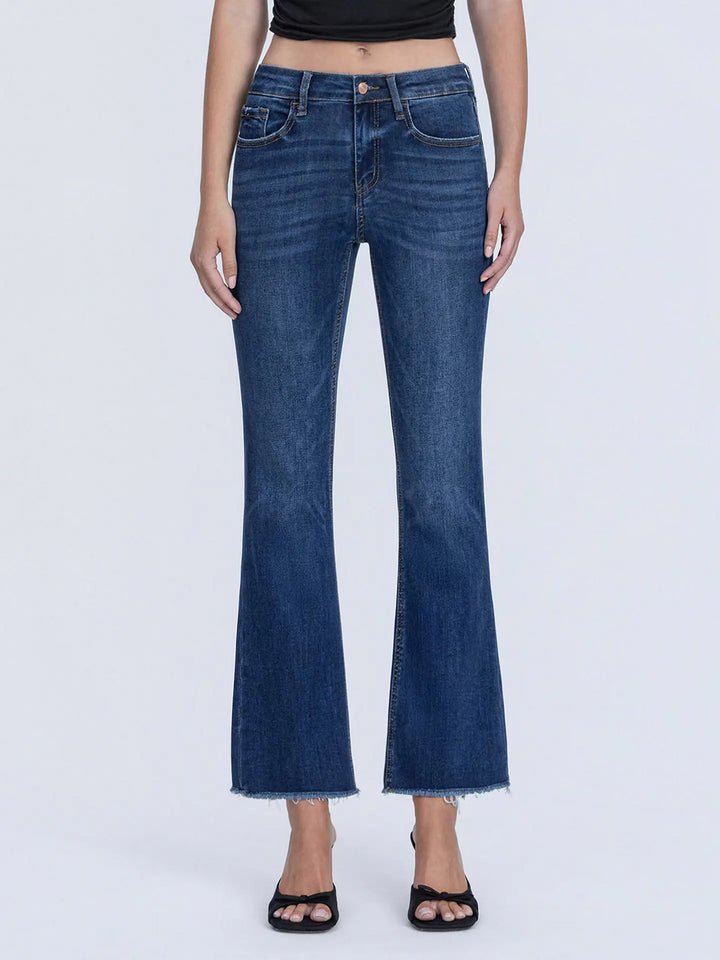 Person wearing blue flared jeans on a white background