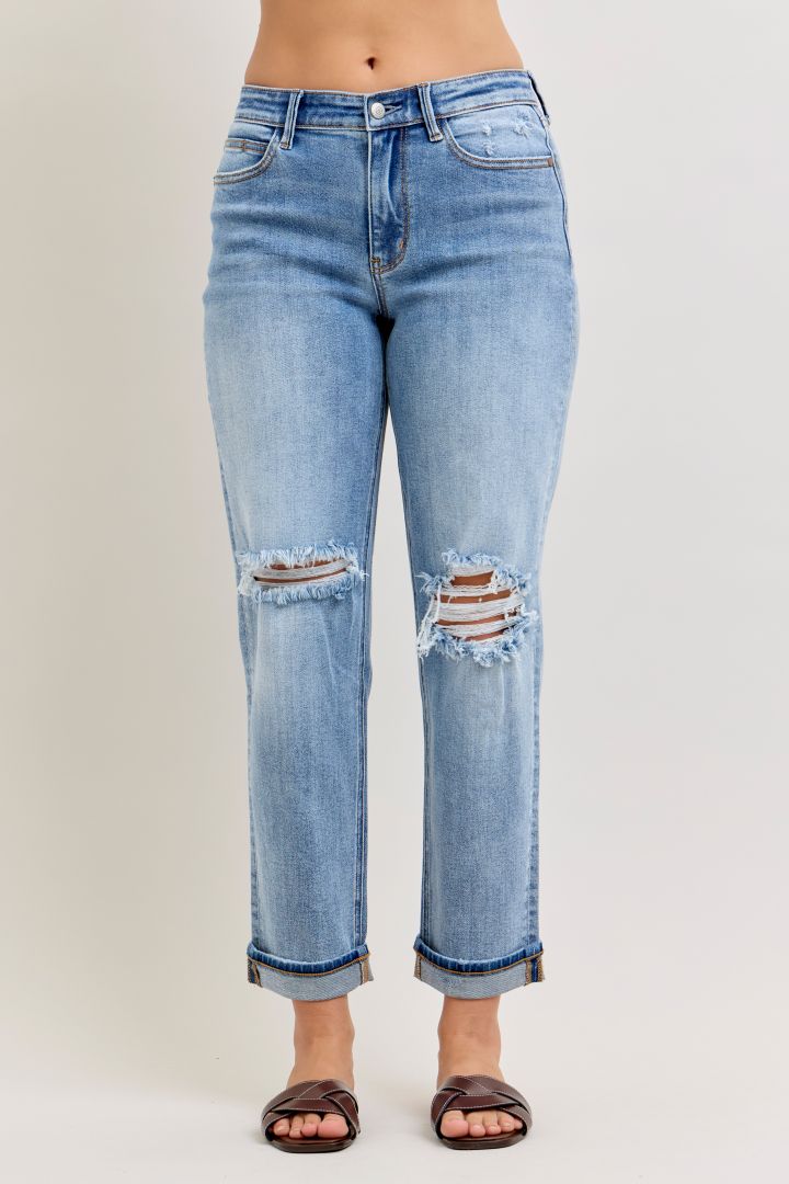 Light blue jeans with distressing details on a plain background