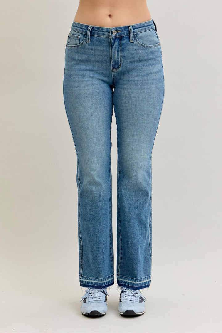 Blue jeans worn by a person on a plain background