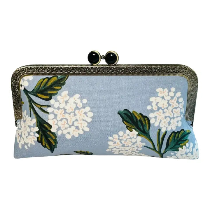 blue clutch purse with white hydrangea print and decorative clasp closure
