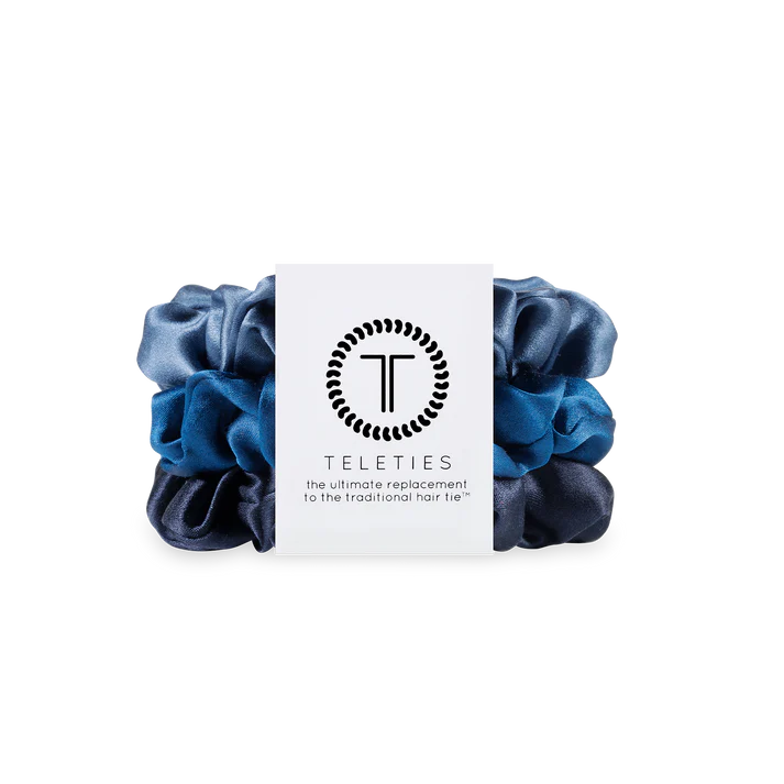 Set of blue scrunchies with a Teleties branded card on a white background