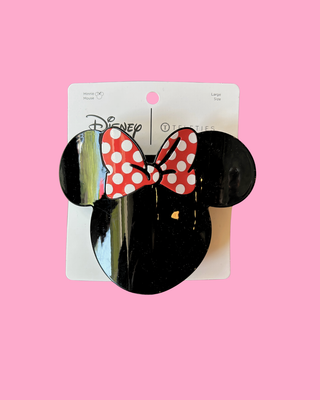 Black mouse ears with a red polka dot bow on a pink background
