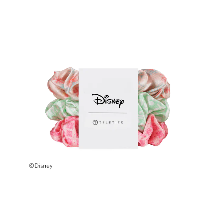 A set of four Disney Teleties scrunchies in pastel colors, wrapped in a white paper band featuring the Disney logo.