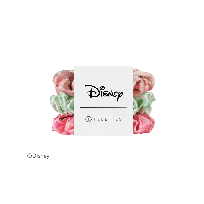 Four Disney Teleties scrunchies in pink and mint green marbled fabric, arranged behind a white paper band featuring the Disney logo.