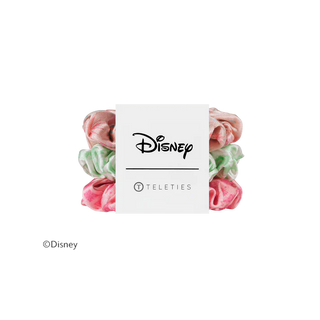 Four Disney Teleties scrunchies in pink and mint green marbled fabric, arranged behind a white paper band featuring the Disney logo.