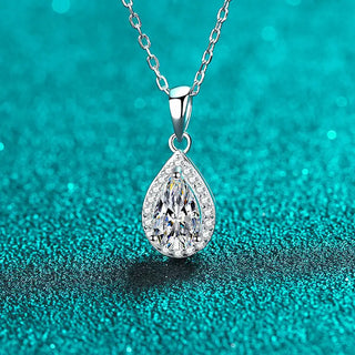 Silver teardrop pendant necklace on a teal glittery background