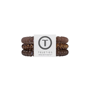 Three Teleties stretch bracelets in dark brown, medium brown, and leopard print, wrapped together with a white paper band featuring the Teleties logo.